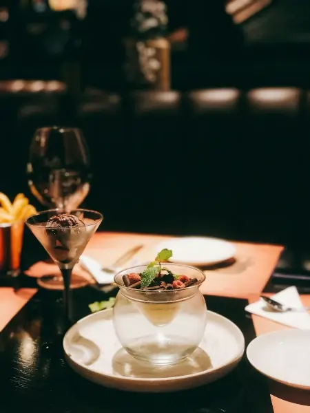 An elegant dessert next to a cocktail glass